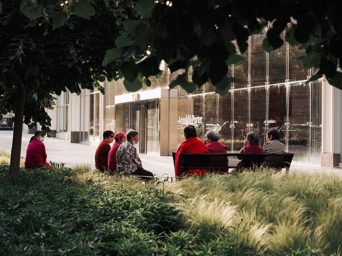 Residents sitting on benches in the garden of a senior living community